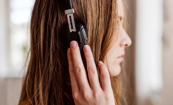 Close-up van jonge vrouwelijke student met koptelefoon, zijaanzicht. — Stockfoto