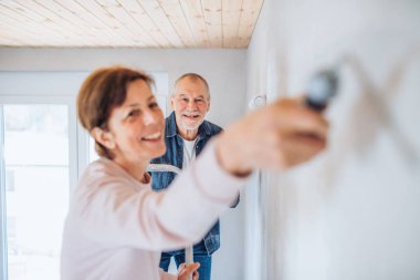 Yeni evde Kıdemli çift boyama duvarları, tehcir kavramı.