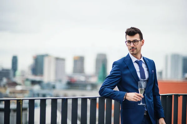 Un jeune homme d'affaires avec verre lors d'une fête en plein air sur la terrasse du toit en ville . — Photo