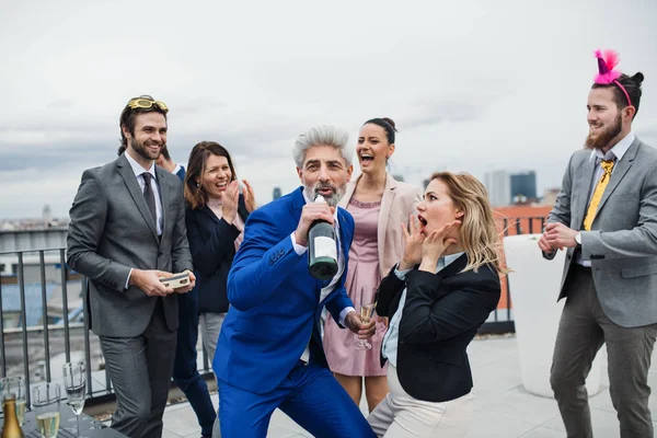 A group of joyful businesspeople having a party outdoors on roof terrace in city. — Stock Photo, Image