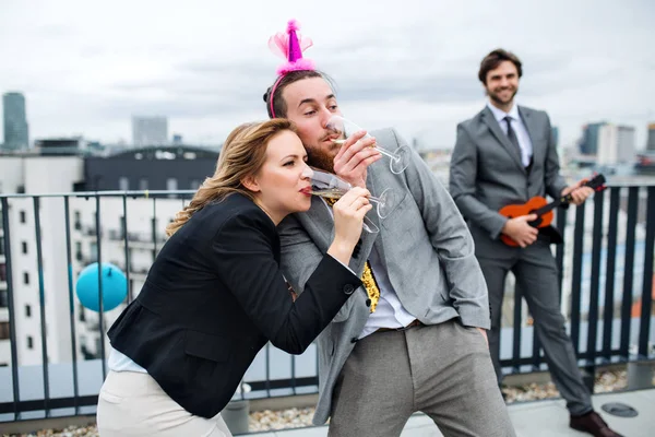 En grupp glada affärsmän som har en fest utomhus på takterrassen i staden. — Stockfoto