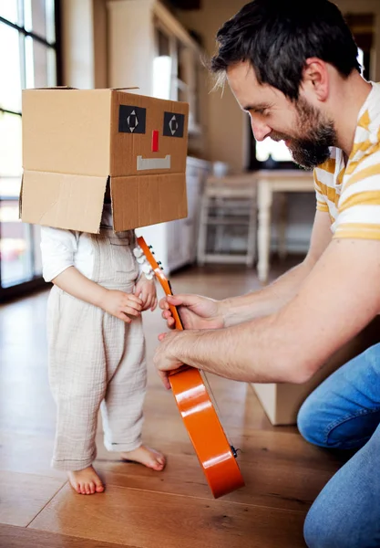 Une petite fille avec père jouant à l'intérieur à la maison . — Photo