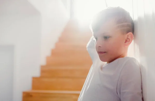 Un niño pequeño de pie junto a las escaleras. Copiar espacio . — Foto de Stock