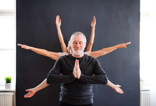 Starszy mężczyzna z wieloma ramionami robi ćwiczenia jogi w klubie centrum społeczności. — Zdjęcie stockowe
