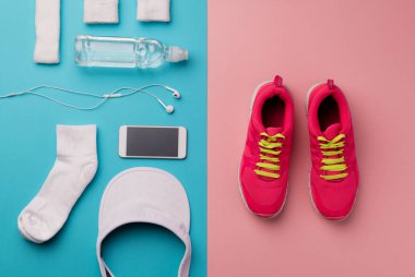 Koşu ayakkabıları ve renk arka plan üzerinde diğer spor ekipmanları bir stüdyo çekim.