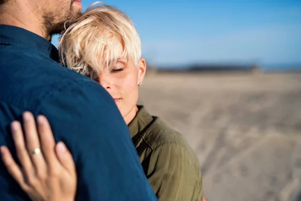 Sección media de la joven pareja de pie al aire libre en la playa, abrazos. Copiar espacio . —  Fotos de Stock