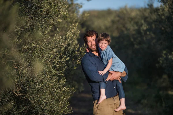 Padre con hija pequeña de pie al aire libre junto al olivo . — Foto de Stock