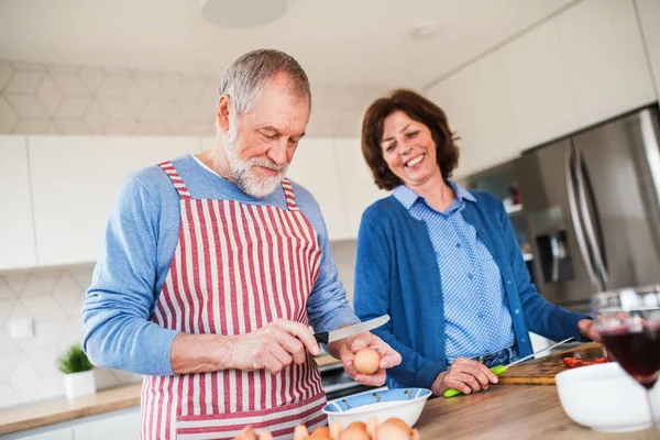 Ritratto di una coppia di anziani innamorati in casa, che cucina . — Foto Stock