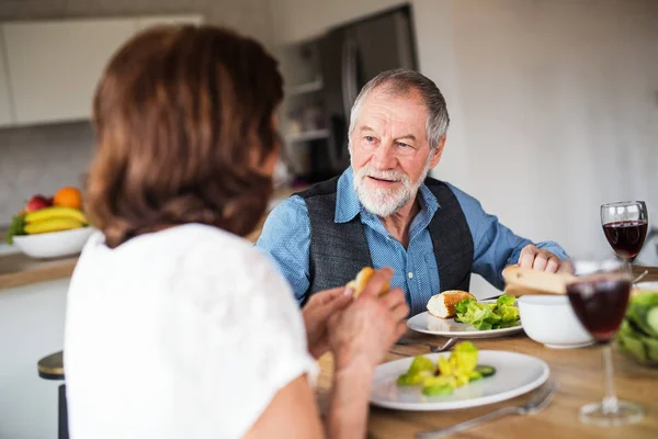 Casal de idosos apaixonados almoçando dentro de casa, conversando . — Fotografia de Stock