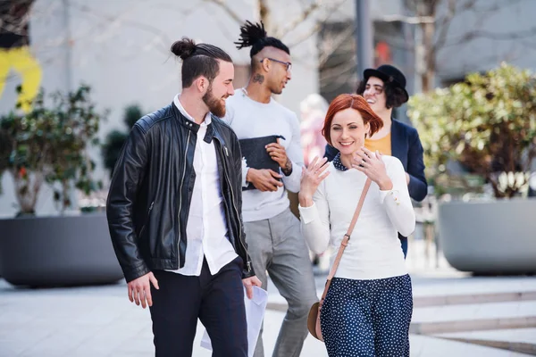 Group of young businesspeople walking outdoors in courtyard. — Stock Photo, Image