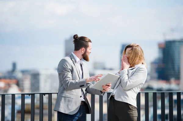 Dois jovens empresários com tablet em pé em um terraço fora do escritório, trabalhando . — Fotografia de Stock