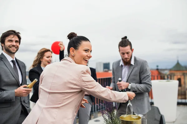 Een groep vrolijke zakenlui die een feestje hebben buiten op het dakterras in de stad. — Stockfoto