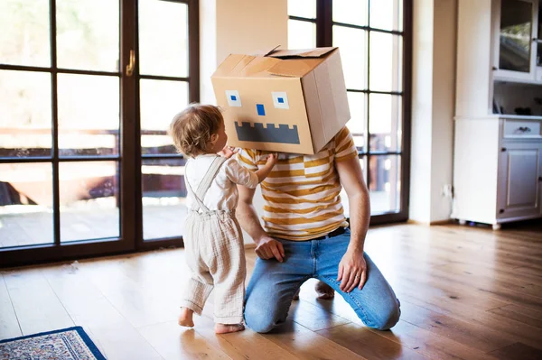 Una niña con padre jugando en casa en casa . — Foto de Stock