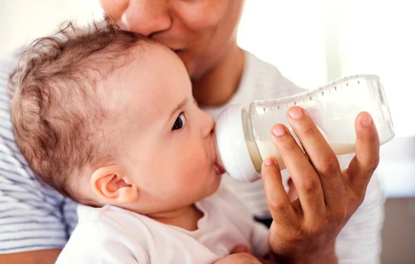 Baba şişe evde evde küçük bir bebek oğlu besleme bir orta bölümü. — Stok fotoğraf