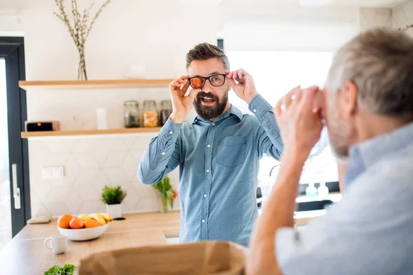 Adulto hipster hijo y padre mayor en el interior en la cocina en casa, divertirse . —  Fotos de Stock