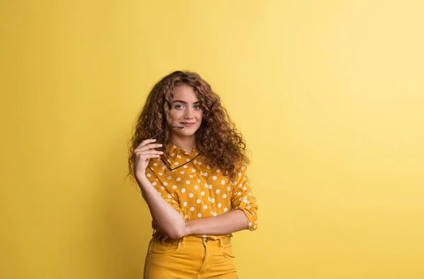 Porträt einer jungen Frau in einem Atelier auf gelbem Hintergrund. — Stockfoto