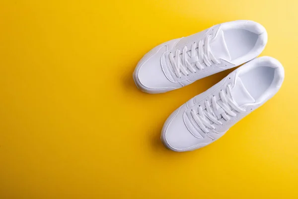 Uma foto de estúdio de sapatos de corrida brancos no fundo amarelo. Depósito plano . — Fotografia de Stock