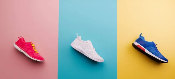 Una foto de estudio de zapatillas de running sobre fondo de color brillante. Puesta plana . — Foto de Stock