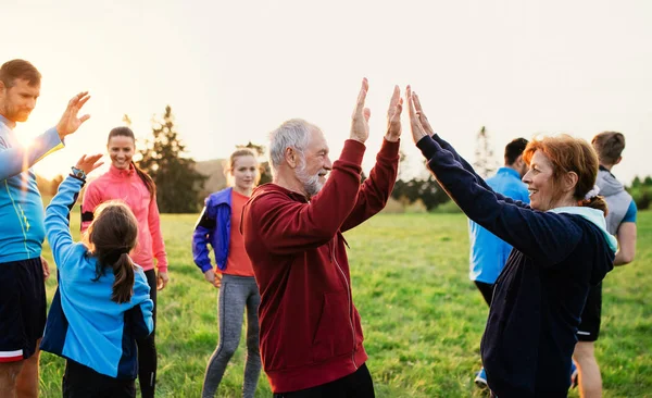 Gran grupo de personas en forma y activas descansando después de hacer ejercicio en la naturaleza . — Foto de Stock