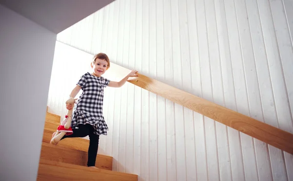 Merdivenlerden aşağı yürüyen yumuşak bir oyuncak ile küçük bir çocuk. — Stok fotoğraf