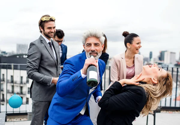 Un grupo de empresarios alegres haciendo una fiesta al aire libre en la azotea de la ciudad . — Foto de Stock