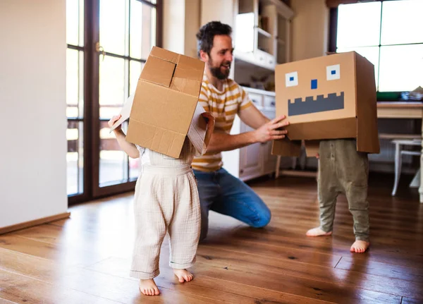 Twee peuter kinderen met vader spelen binnenshuis thuis. — Stockfoto