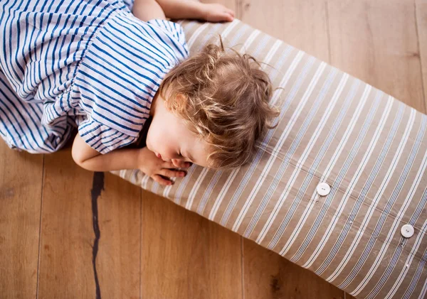 自宅で屋内の床に横たわって寝ている幼児の女の子のトップビュー. — ストック写真