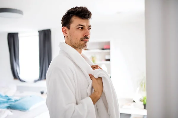 寝室にバスローブを持つ若い男、朝のルーチン. — ストック写真