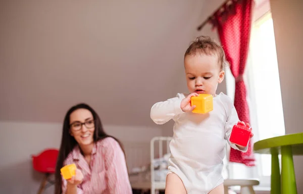 Joven madre con su pequeño hijo en casa, jugando . —  Fotos de Stock