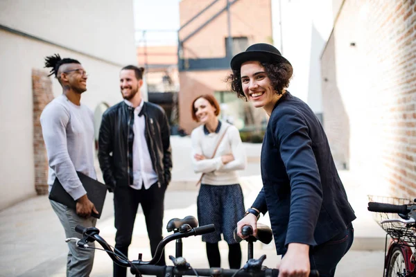 屋外に立つ自転車を持つ幸せな若いビジネスの人々. — ストック写真