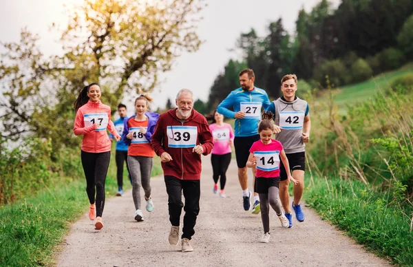 Large group of multi generation people running a race competition in nature. — Stock Photo, Image