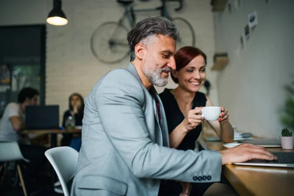 Mann und Frau bei einem Geschäftstreffen in einem Café mit Laptop. — Stockfoto