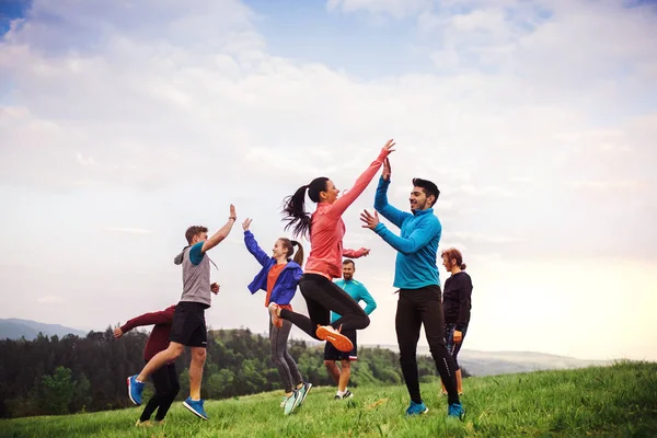 Doğada egzersiz yaptıktan sonra atlama uygun ve aktif insanların büyük bir grup. — Stok fotoğraf