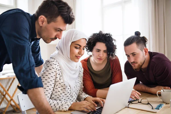 Dizüstü bilgisayar kapalı, ev paylaşım konsepti ile genç arkadaş çok ırklı bir grup.