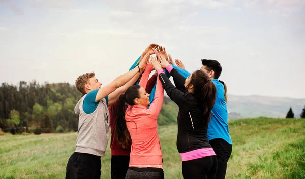 Large group of fit and active people resting after doing exercise in nature. — Stock Photo, Image