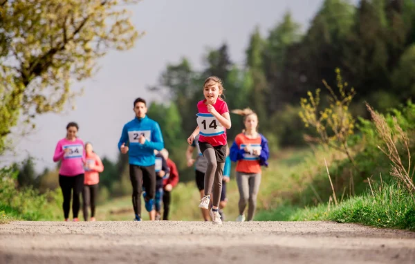 Gran grupo de personas de varias generaciones corriendo una competición de carreras en la naturaleza . — Foto de Stock