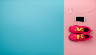 Renkli arka planda çalışan ayakkabı ve akıllı telefon bir stüdyo çekim. Düz yatma.