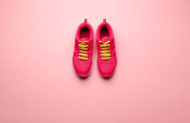 Pembe arka planda bir çift koşu ayakkabısı bir stüdyo çekimi. Düz yatıyordu.