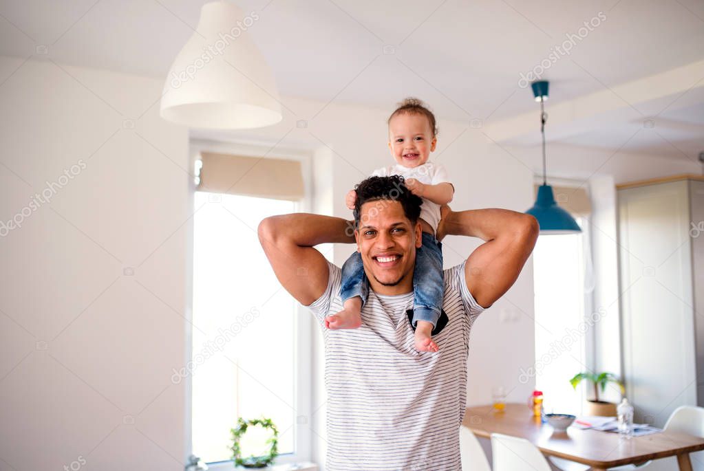 Father and small toddler son indoors at home, playing.