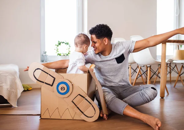 Pai e pequeno filho criança dentro de casa, brincando . — Fotografia de Stock