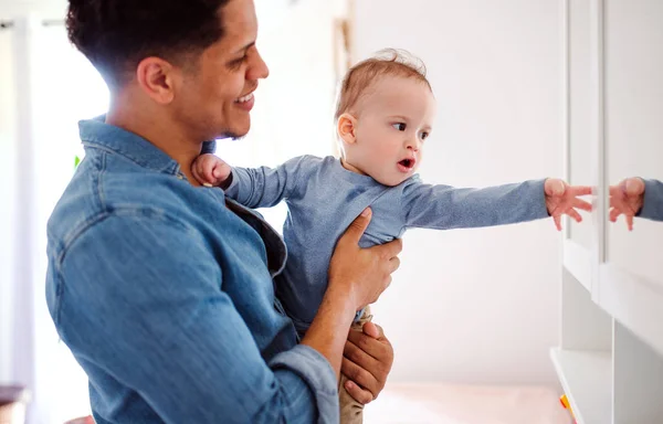 Um retrato de pai e pequeno filho criança dentro de casa, brincando . — Fotografia de Stock