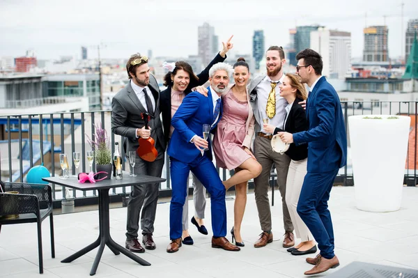 En grupp glada affärsmän som har en fest utomhus på takterrassen i staden. — Stockfoto