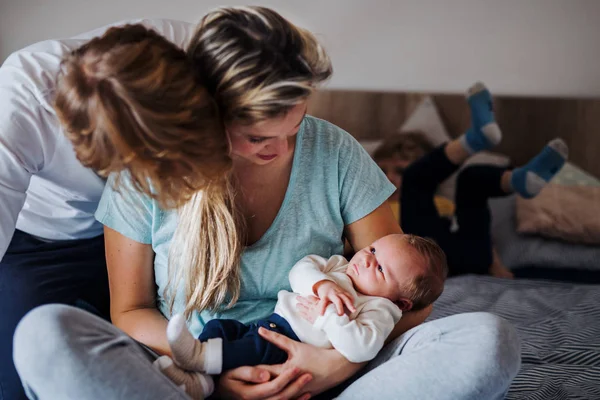 집에서 신생아와 작은 유아 아들을 가진 젊은 부모. — 스톡 사진
