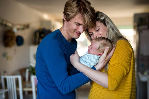 Belos pais jovens com um bebê recém-nascido em casa . — Fotografia de Stock