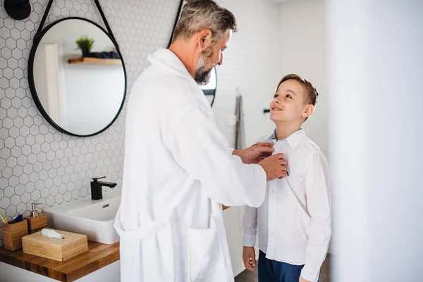Volwassen vader met kleine zoon gekleed in de badkamer in de ochtend. — Stockfoto