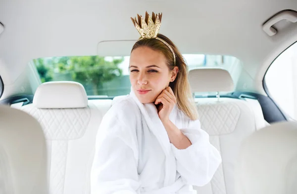 Junge Frau mit Party-Accessoires sitzt im Auto und hat Spaß. — Stockfoto