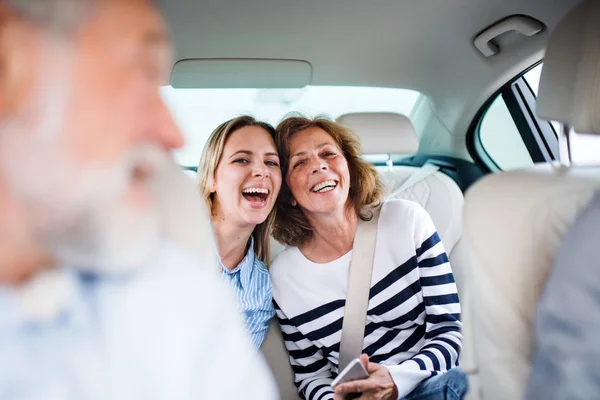 Vrolijke volwassenen die in de auto zitten, op reis gaan. — Stockfoto