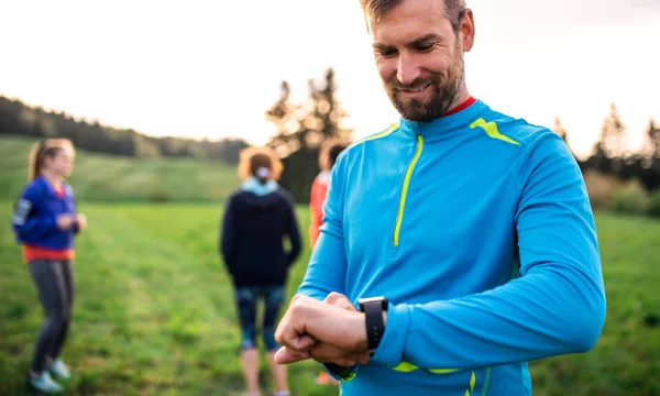 Porträt eines Menschen mit einer großen Gruppe von Menschen, die in der Natur Sport treiben. — Stockfoto