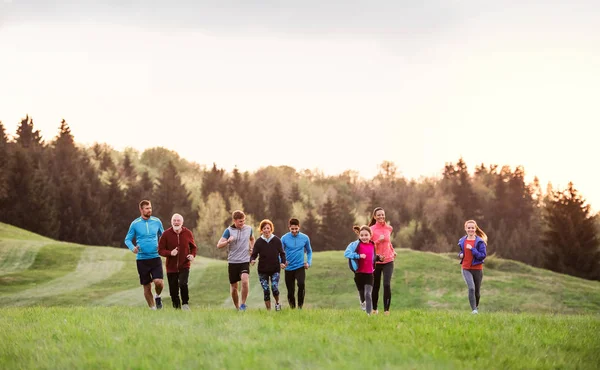 Velká skupina lidí se přes zemi běžící v přírodě. — Stock fotografie