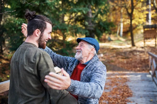 Senior far och hans son på promenad i naturen, kramar och pratar. — Stockfoto